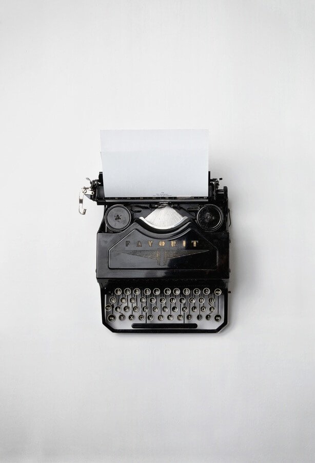 Máquina de escribir vintage sobre fondo blanco, representando mini guías prácticas y reflexivas del Plan Filósofo de Mentes Peripatéticas.